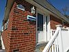 A brick house with a white railing

Description automatically generated